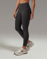 Woman wearing black athletic outfit on a gray background