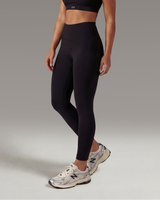 Woman wearing black athletic outfit on a gray background