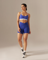 Woman wearing a blue athletic outfit on a beige background