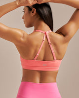 Person wearing a pink sports bra and leggings on a beige background