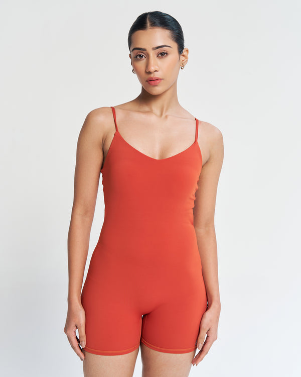 Rich and radiant - our lava orange playsuit on an athletic model. Experience the body-hugging fit, no front seam, soft neckline, and adjustable spaghetti straps. Full support with a built-in shelf bra. Quick Drying, 4 Way Stretch, Lightweight & Breathable