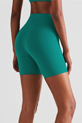 athletic female model posing in premium green high waisted shorts that is squat proof and perfect for yoga, running, dancing, gym and athletic activities