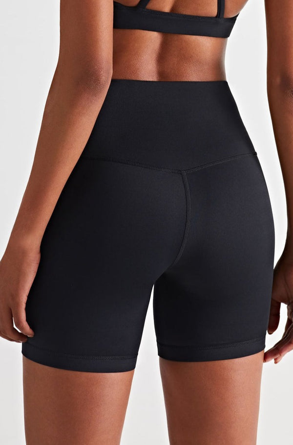athletic model posing in premium black high waisted and squat proof bike shorts suitable for yoga, running, dancing, gym and athletic activities