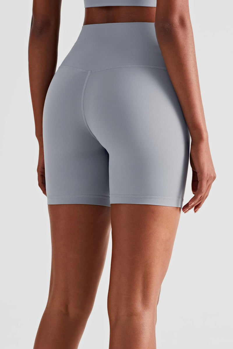 athletic female model posing in premium Grey high waisted and squat proof bike shorts suitable for yoga, running, dancing, gym and athletic activities