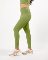 Female model posing in green leggings suitable for workout with a high waist and squat-proof fit, perfect for any athletic activity