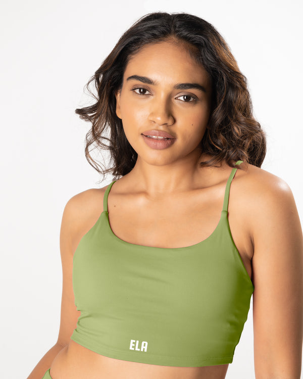Female model wearing a matcha green sports bra, suitable for a variety of workout and athletic activities.