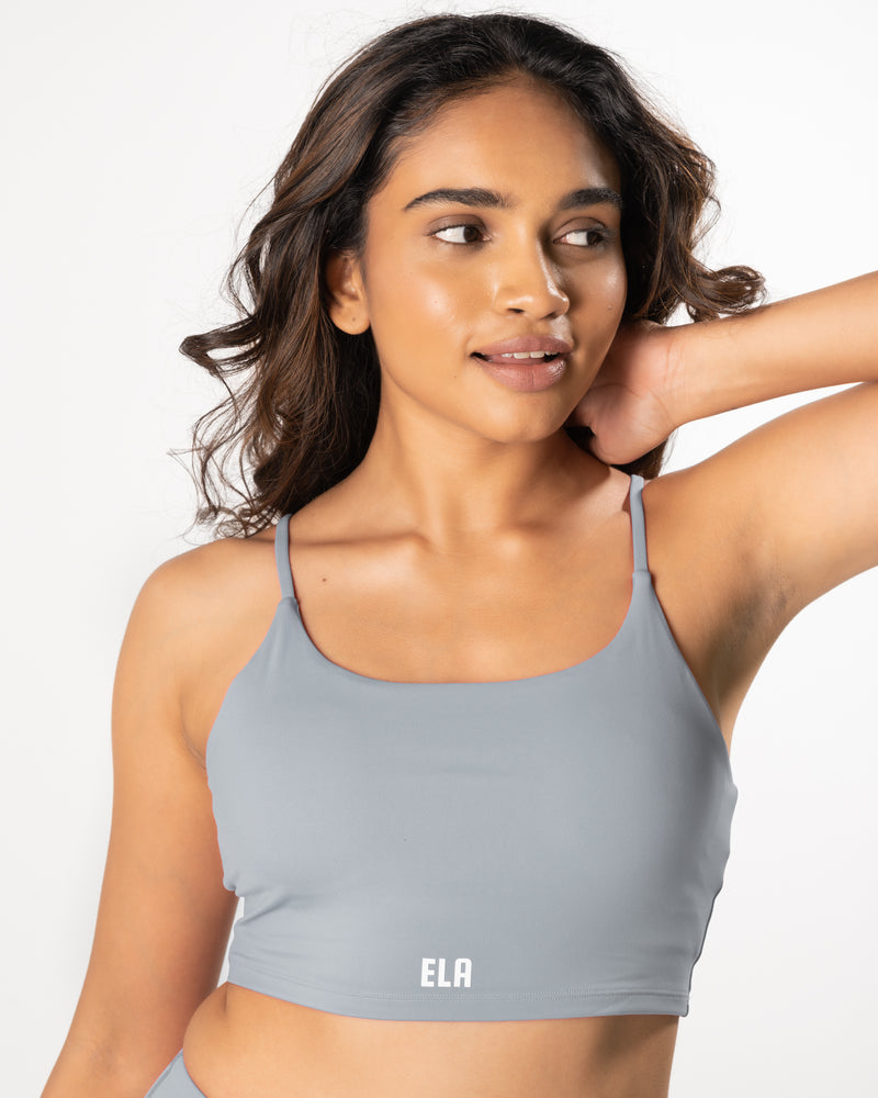 Female model wearing a grey sports bra, suitable for high impact workout activities.