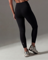 Person wearing black leggings with a gray background