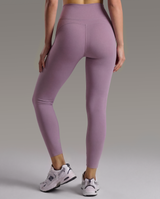 woman wearing purple leggings on a gray background