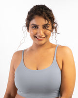 a plus size female model wearing a grey sports bra, suitable for a variety of workout and athletic activities.