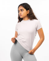 Athletic woman wearing the pale grey Performance Tee, a performance-driven workout top that offers both style and functionality, ensuring a comfortable and focused workout experience