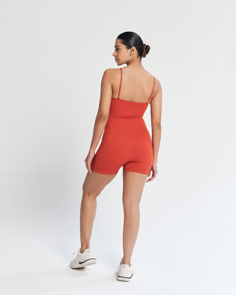 Fall in love with fitness in our lava orange playsuit. A body-hugging fit, seamless front, soft neckline, and adjustable spaghetti straps for your active lifestyle. Full support with a built-in shelf bra. Quick Drying, 4 Way Stretch, Lightweight & Breathable