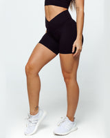 female athletic model wearing buttery smooth bike shorts perfect for running, biking and daily life. The high waistband shows the criss cross feature with wrapover waistline and shows squat proof feature.
