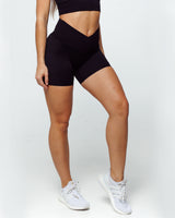 female athletic model wearing buttery smooth bike shorts perfect for running, biking and daily life. The high waistband shows the criss cross feature with wrapover waistline and shows squat proof feature.