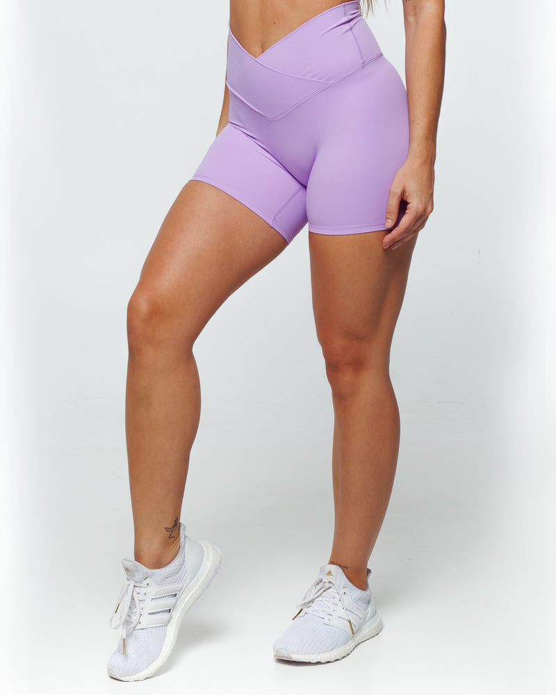female athletic model wearing soft lilac bike shorts perfect for running, biking and daily life. high waistband and is squat proof feature.