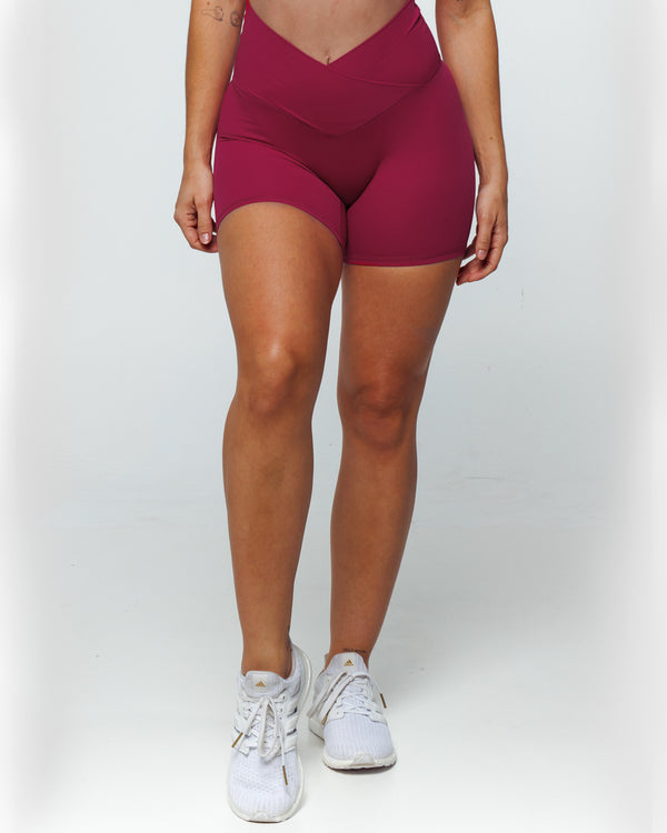 Magenta Bike shorts on a female fit model highlighting Pinch-free Criss Cross High Waistband, Anti-Camel Toe, Seam-Free Front Panel, Slimming + Buttery-Smooth, and Squat-Proof features