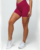 Magenta Bike shorts on a female fit model highlighting Pinch-free Criss Cross High Waistband, Anti-Camel Toe, Seam-Free Front Panel, Slimming + Buttery-Smooth, and Squat-Proof features