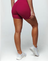 Magenta Bike shorts on a female fit model from rear view highlighting Seam Panel for beautiful butt shaping, Slimming + Buttery-Smooth, and Squat-Proof features