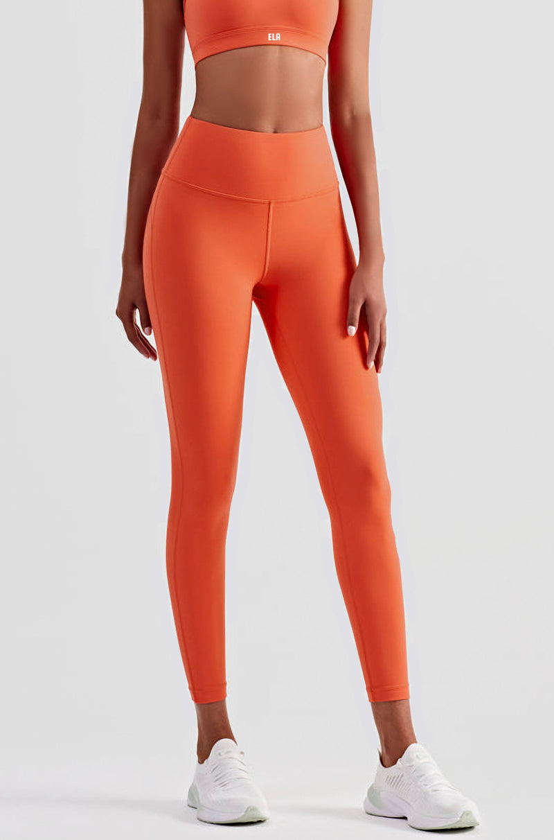 Female model posing to display Orange buttery smooth leggings with a high waist and ankle-length fit suitable for gym, yoga and other athletic activities