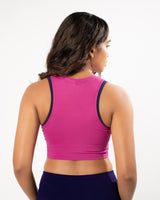 Female model showing the back of fuschia pink high neck sports bra 