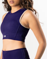 female model showing purple blue high neck sports bra made for gym and workout