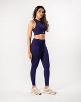 female model in a purple blue high neck sports bra and matching legging, showcasing the coordinated activewear set for workout