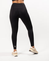 Female model posing to display black buttery smooth leggings with a high waist and ankle-length fit, perfect for any athletic activity and suitable for gym, yoga and other workout activities. 