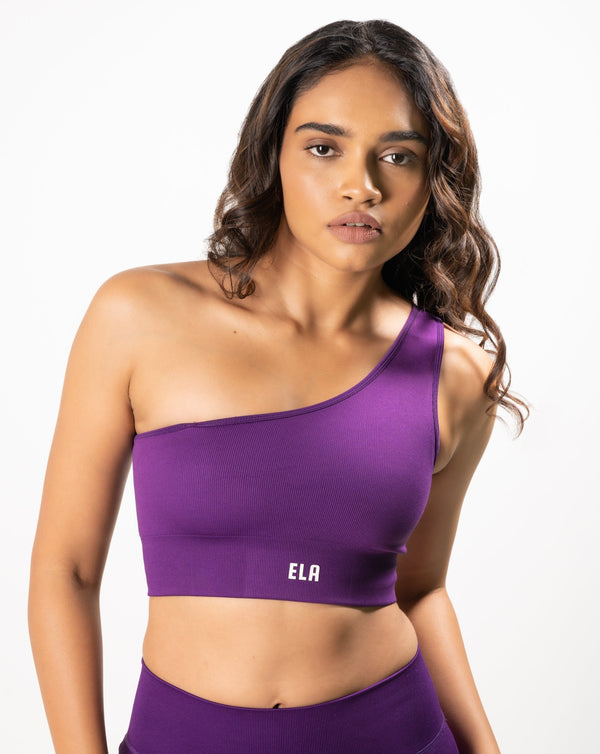 model wearing a one shoulder sports bra with optional detachable second strap 