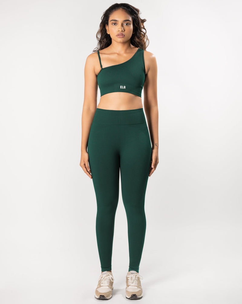 Model posing in a one shoulder sports bra and matching leggings, showcasing the coordinated activewear set.