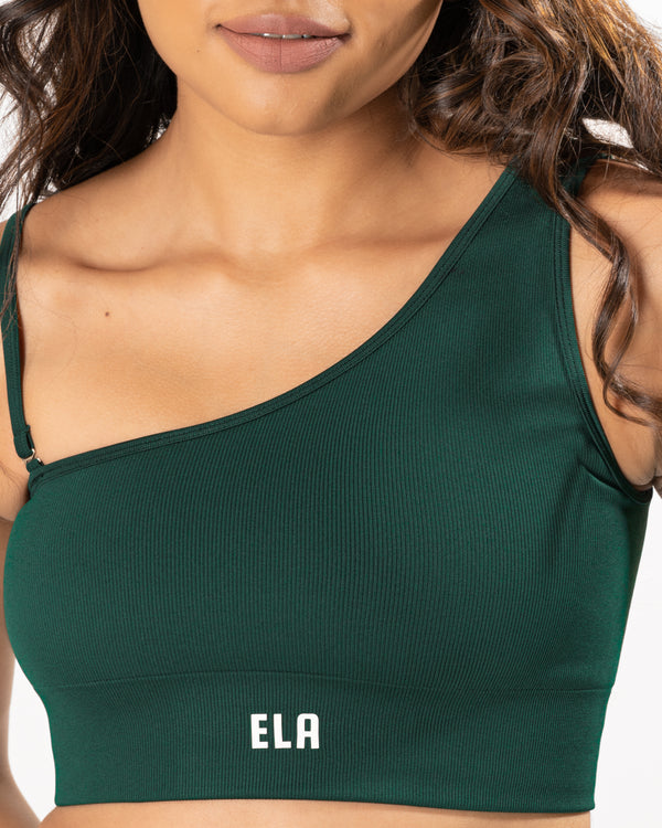 Close up of a model wearing a one shoulder sports bra with a ribbed texture, highlighting the detail and quality of the fabric
