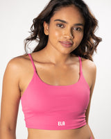 Model wearing a pink sports bra, suitable for a variety of workout activities.