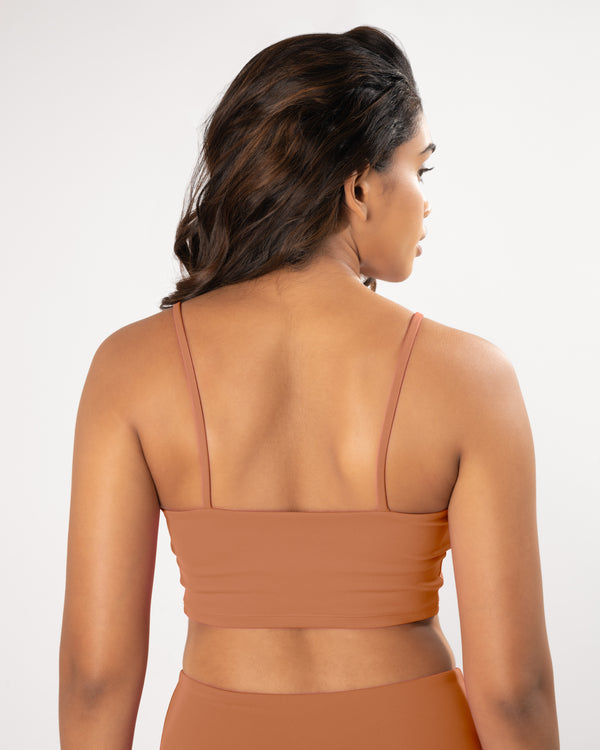 Female Model in a beige sports bra with straps suitable for high impact workout and gym or yoga activities