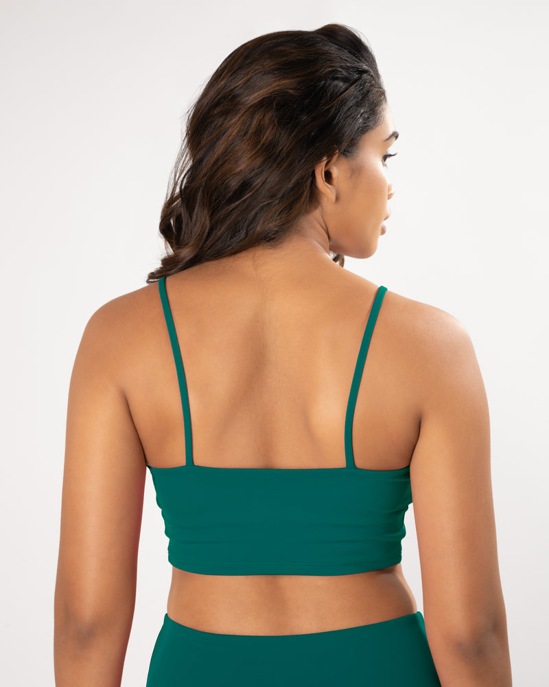 Female Model wearing and showcasing the back of a teal green sports bra, suitable for a variety of workout activities 