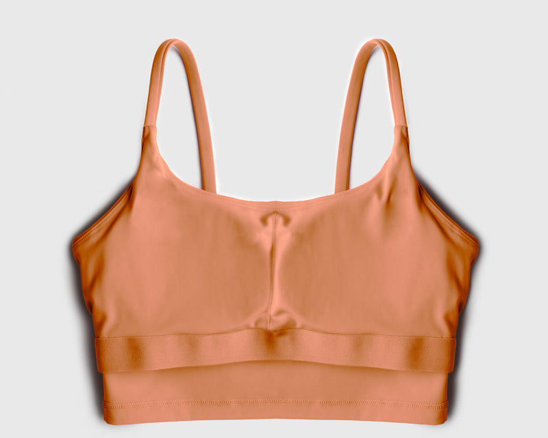 Flatlay of a beige sports bra showing internal structure of built-in bra pads for maximum support during high intensity workout