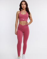 female model in pink halter neck sports bra with matching leggings suitable for variety of athletic activities, gym, yoga and workout.