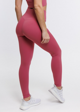 A female model showing the back of the ButterBod Hourglass Leggings. The high-waisted wrap design and V-cut waistband accentuate her curves, while the booty-lifting back seam provides a flattering lift. The leggings have a soft matte finish, medium compression, and are made from 4-way stretch fabric for maximum comfort and versatility.